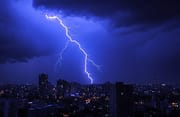 Orage au dessus d'une ville dans la nuit 