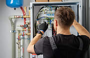 électricien qui intervient dans un tableau électrique 