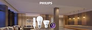 2 produits d'éclairage de la marque Philips devant une représentation d'un grand salon éclairé