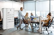 plusieurs personnes dans un bureau en train de travailler avec devant le visuel d'un coffret électrique